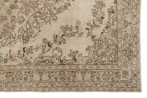 Load image 1 in gallery view. A close-up of the Mamail - Vintage Medallion Rug (6'4 X 9'7) reveals intricate floral and vine patterns in muted beige, brown, and green, with an ornate border featuring geometric motifs—a classic Anatolian heritage design.