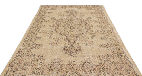 Load image 1 in gallery view. Beige and brown distressed area rug with a traditional central medallion and floral border pattern.