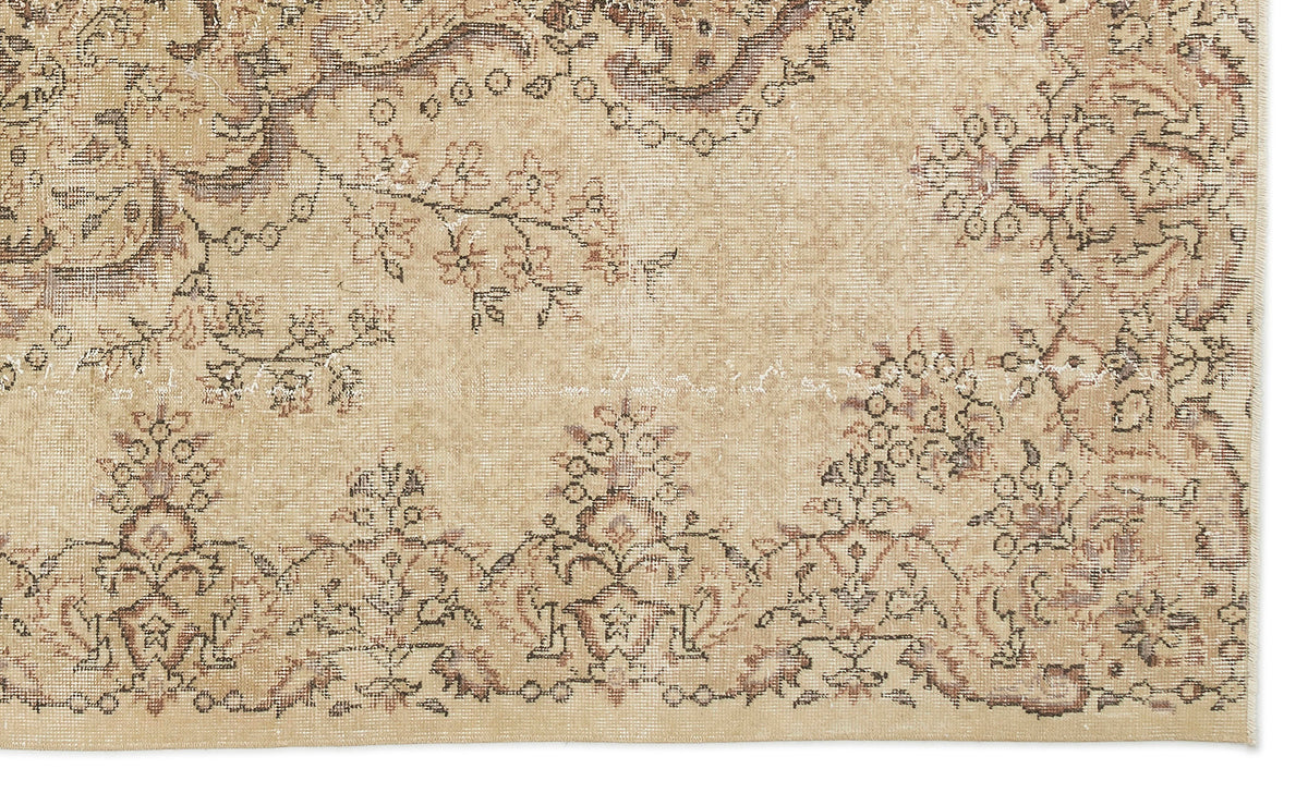 Tan and brown vintage-style rug with a distressed floral medallion pattern and intricate border detail.