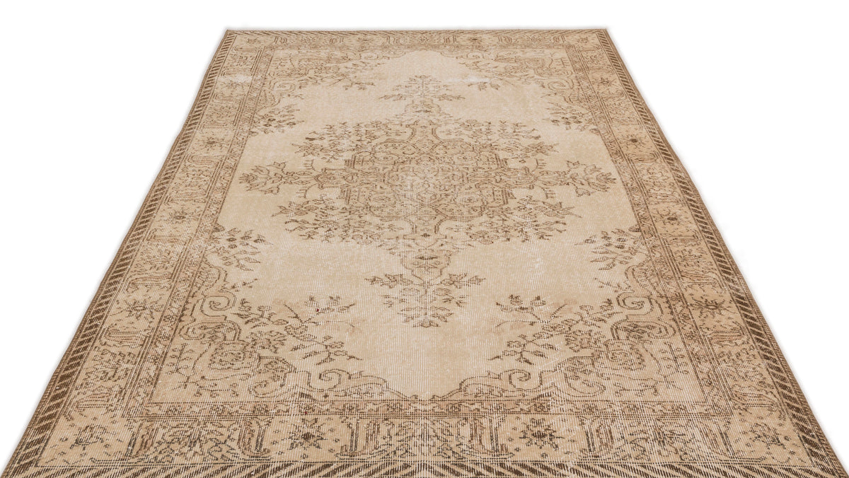 Beige and brown distressed area rug with a traditional floral medallion pattern and ornate border on a white background.