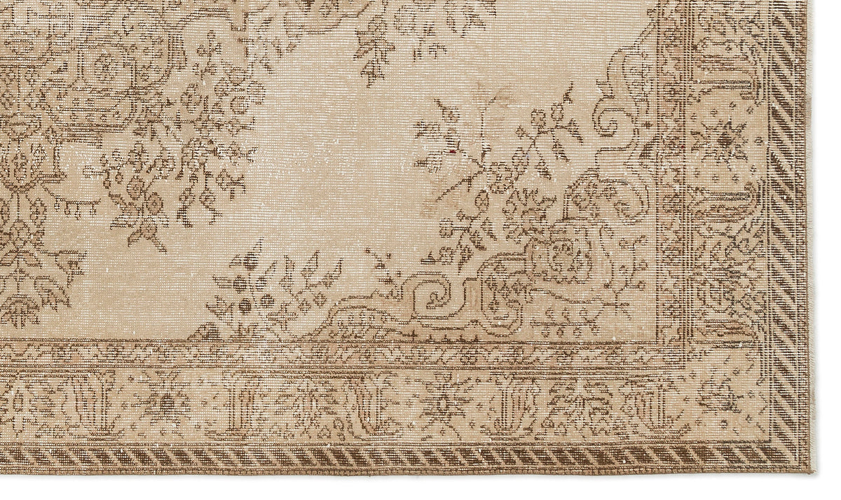 Beige and brown vintage-style rug with a distressed floral medallion pattern and a decorative geometric border.