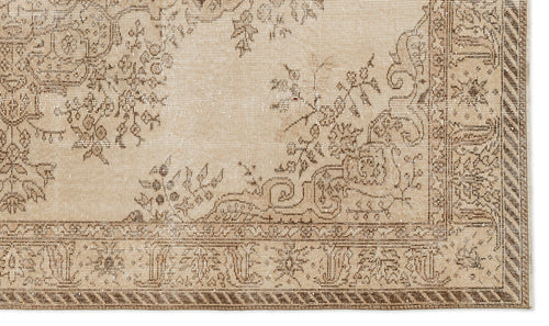 Load image 1 in gallery view. Beige and brown vintage-style rug with a distressed floral medallion pattern and a decorative geometric border.