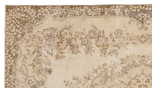 Load image 1 in gallery view. Beige and brown vintage-style rug with a distressed floral pattern and a decorative border.