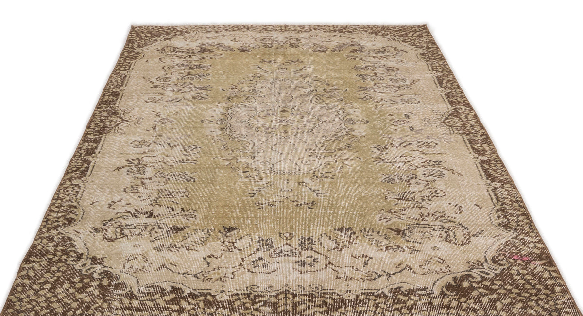 Olive green and brown distressed traditional rug with a central floral medallion and ornate border.