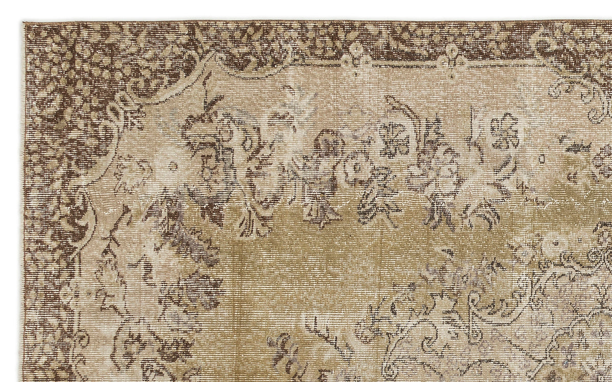 Distressed brown and beige vintage-style rug with a faded floral medallion pattern.