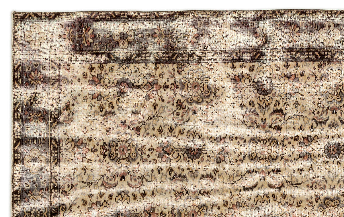 Beige and brown traditional rug with a distressed floral medallion pattern and a detailed geometric border.