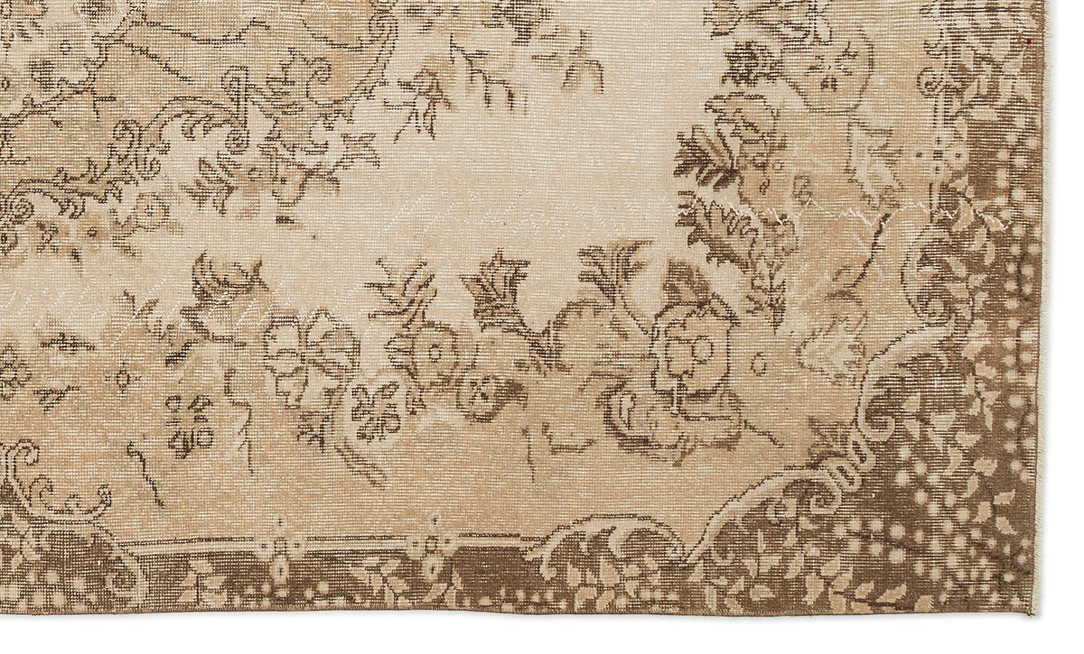 Beige and brown vintage-style rug with a distressed floral medallion pattern.