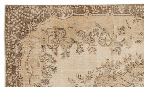Load image 1 in gallery view. Tan and brown vintage-style rug with a distressed floral medallion pattern and ornate border.