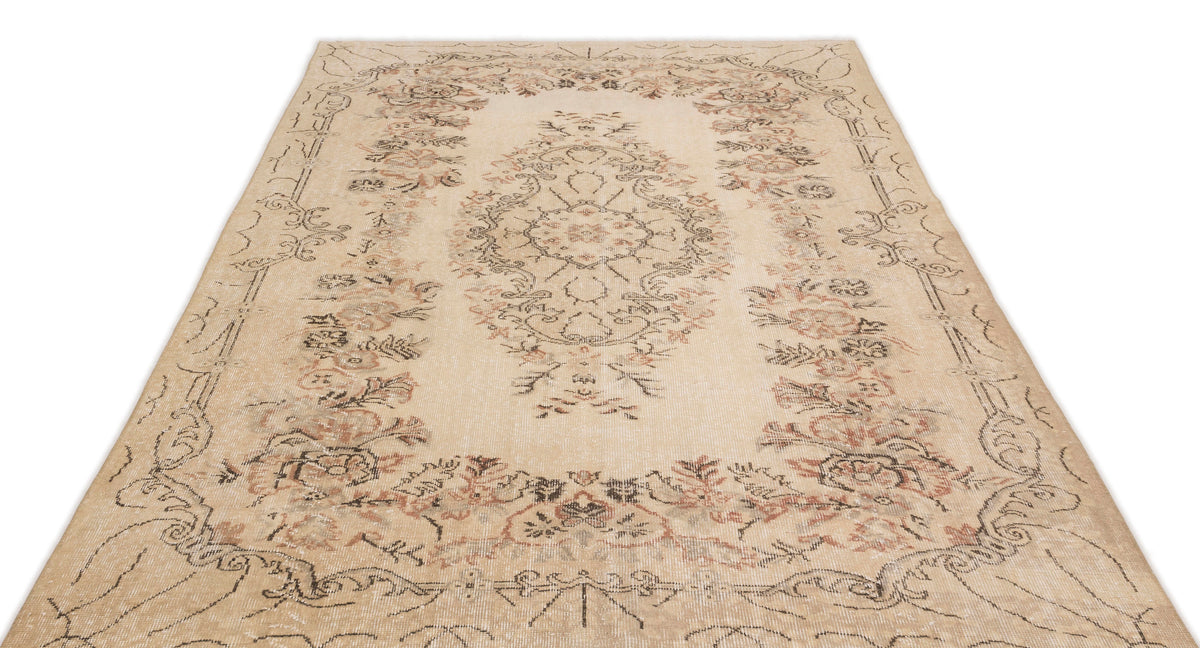 Beige vintage-style rug with a distressed floral medallion pattern in muted brown and terracotta tones.