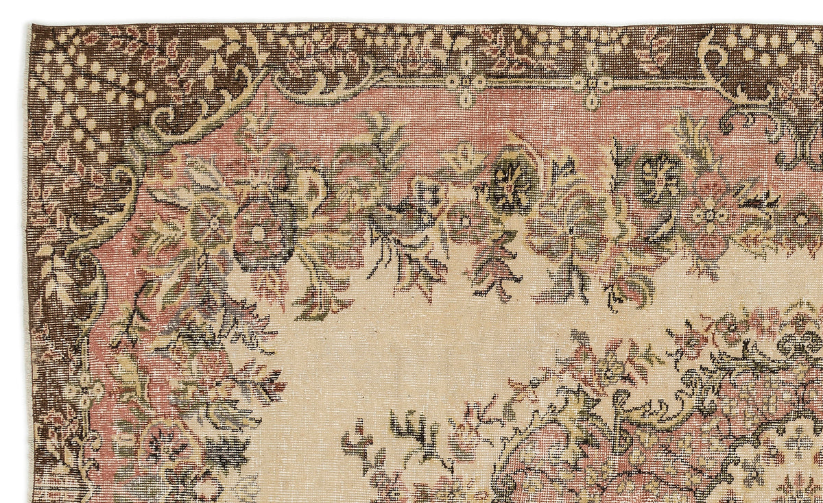 Distressed vintage-style rug with a floral medallion pattern in muted brown, dusty pink, and cream.