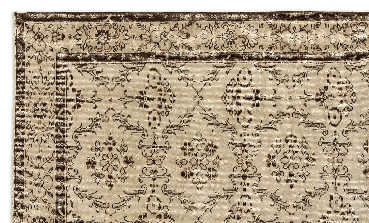 Beige and dark brown rug with a traditional floral medallion border and repeating geometric botanical pattern.