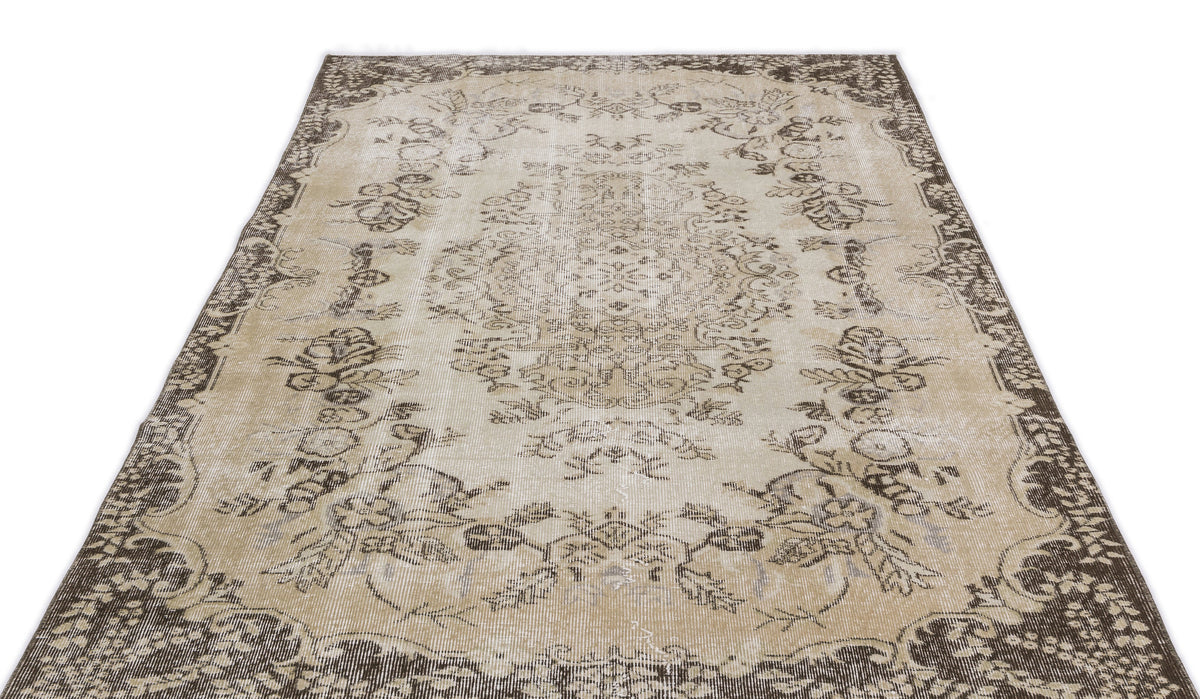 Beige and brown vintage-style rug with a distressed floral medallion pattern and a wide decorative border.