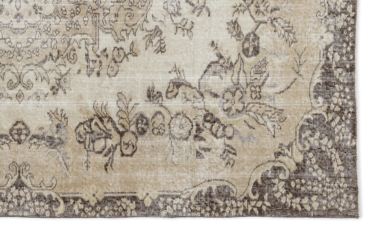 Beige and dark brown vintage-style rug with a distressed floral medallion pattern.