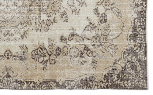 Load image 1 in gallery view. Beige and dark brown vintage-style rug with a distressed floral medallion pattern.