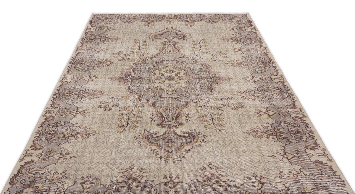 Beige and taupe traditional rug with a distressed central medallion and intricate floral border pattern.