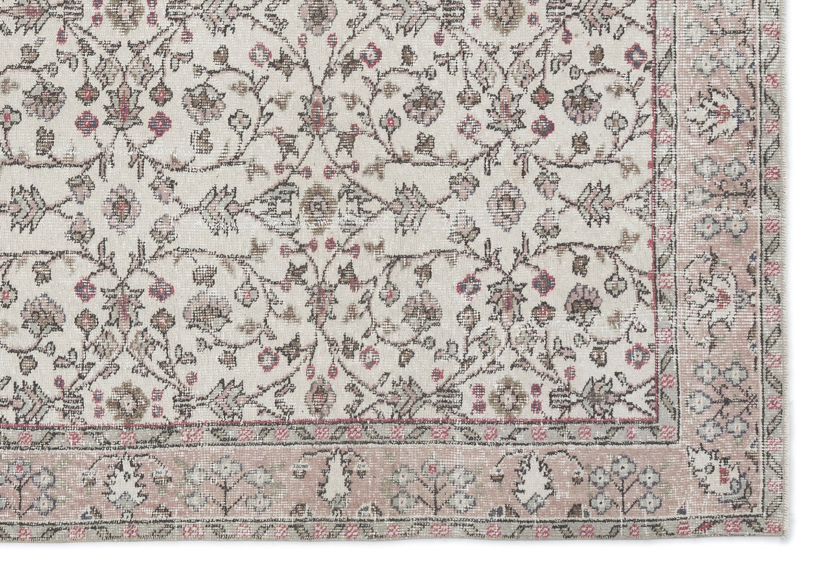 Cream rug with a distressed floral vine pattern in muted pink, grey, and brown, featuring a wide decorative border.