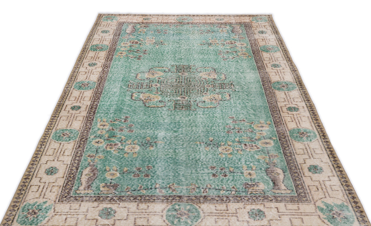 Distressed teal and beige vintage-style rug with a central medallion and floral border on a white background.