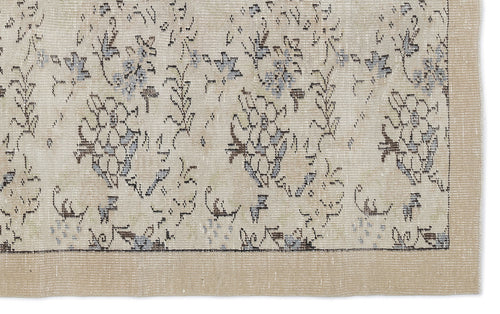 Load image 1 in gallery view. Beige rug with a distressed floral pattern in muted blue and charcoal, featuring a solid border.