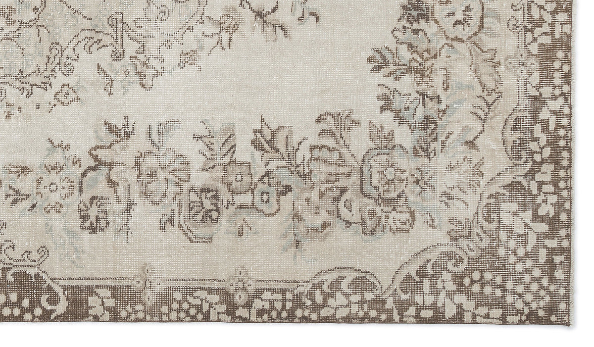 Beige and brown distressed rug with a traditional floral medallion pattern on a white background.