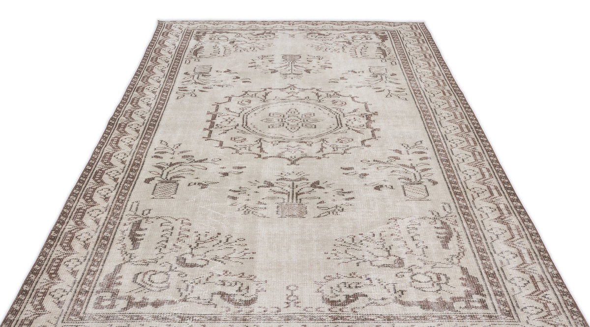 Beige and brown vintage-style rug with a central medallion and floral motifs, isolated on a white background.