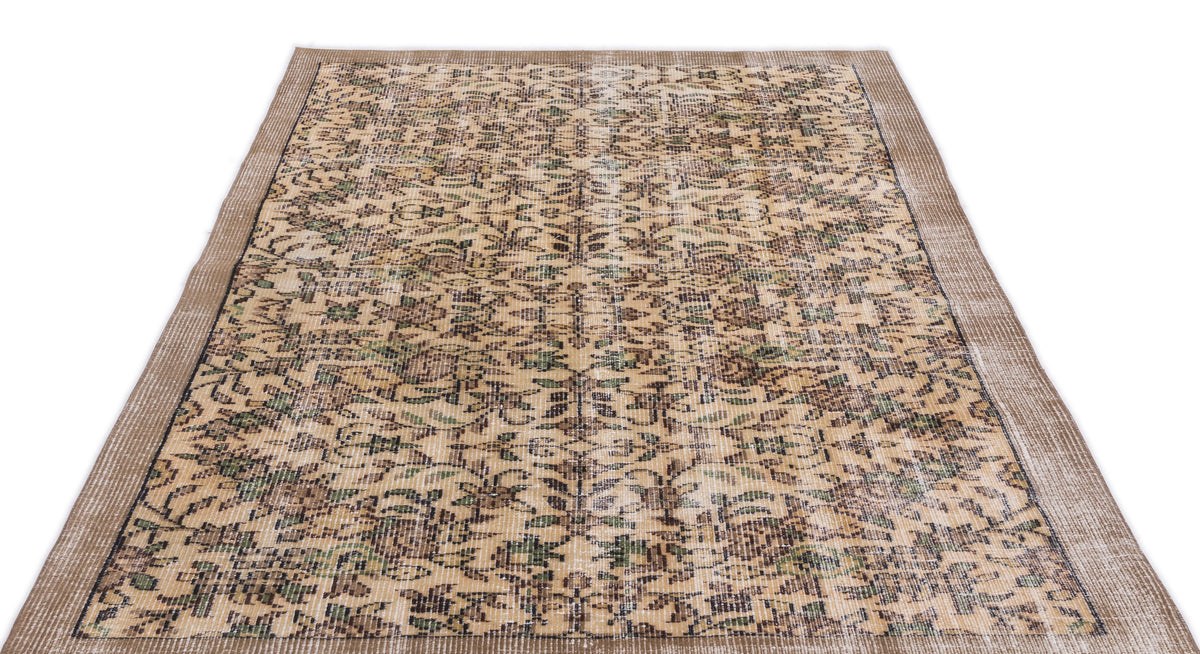 Tan and brown distressed vintage-style rug with a repeating floral medallion pattern and a textured border.