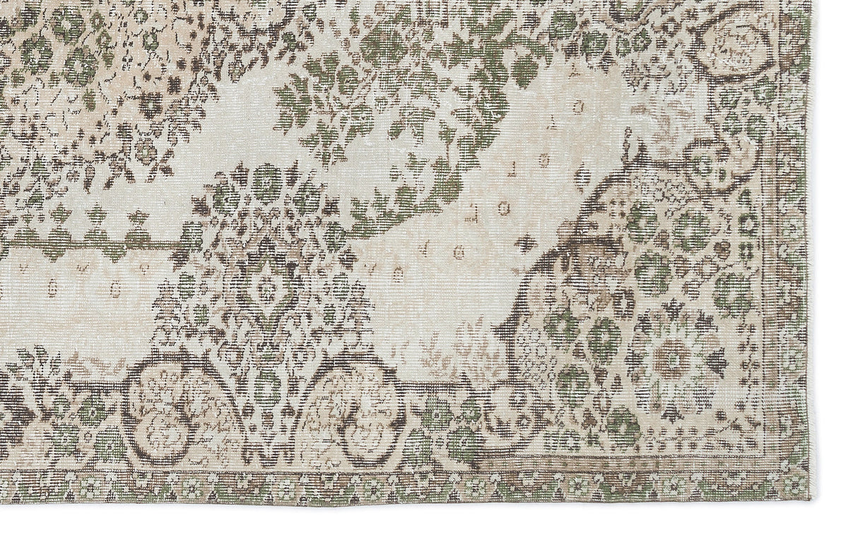 Distressed cream rug with an olive green and brown traditional floral medallion pattern.