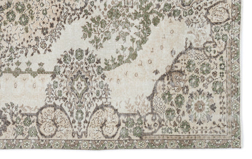 Load image 1 in gallery view. Distressed cream rug with an olive green and brown traditional floral medallion pattern.