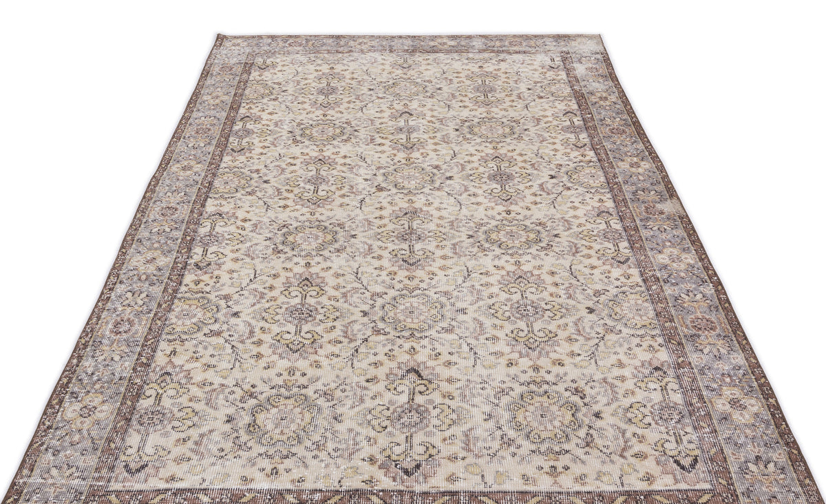 Beige and brown vintage-style rug with a distressed floral medallion pattern and a wide decorative border.