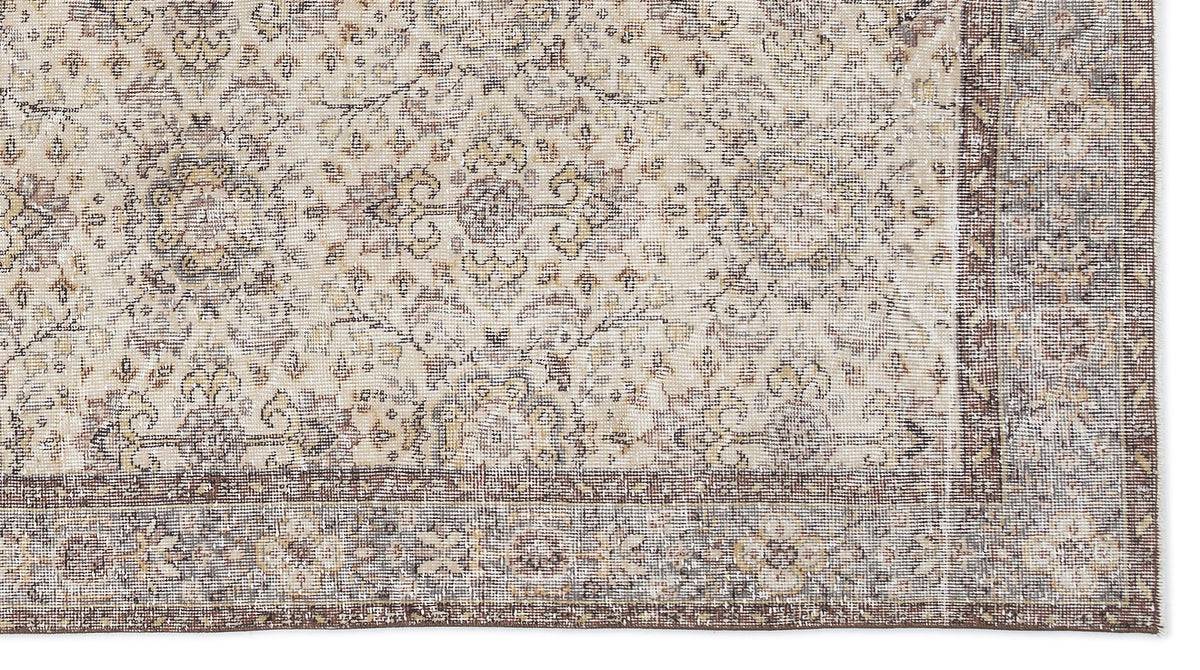 Beige and brown traditional rug with a distressed floral medallion pattern and a wide decorative border.