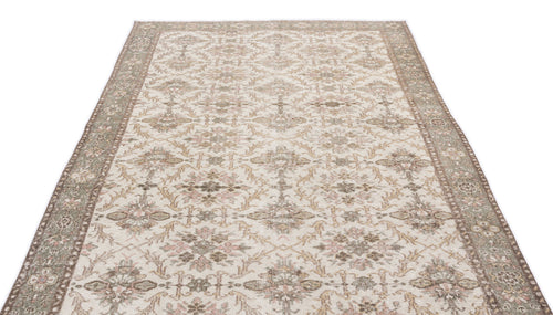 Load image 1 in gallery view. Beige and sage green vintage-style rug with a distressed floral medallion pattern and a wide decorative border.
