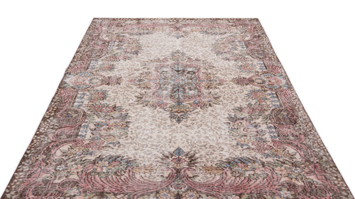 Load image 1 in gallery view. Distressed beige rug with a faded floral medallion pattern in muted pink, blue, and brown tones.