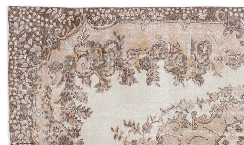 Load image 1 in gallery view. Distressed beige and brown rug with a traditional floral medallion pattern and ornate border.