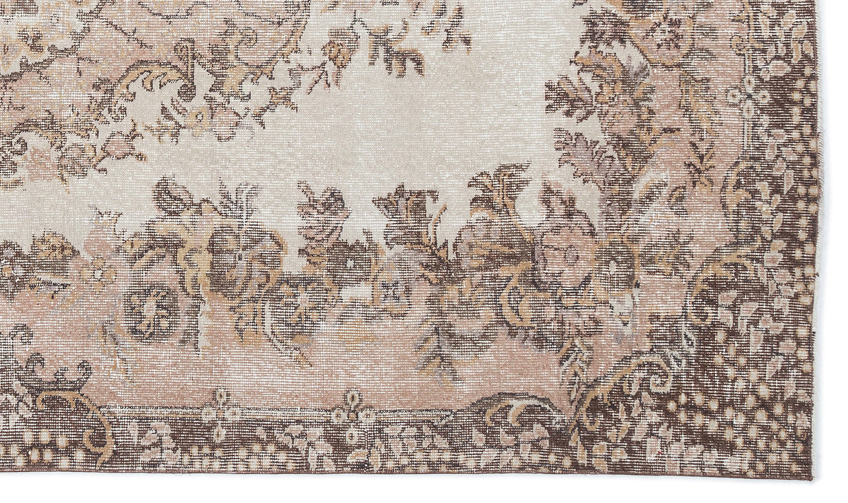 Beige and brown distressed rug with a traditional floral medallion pattern and a detailed border.
