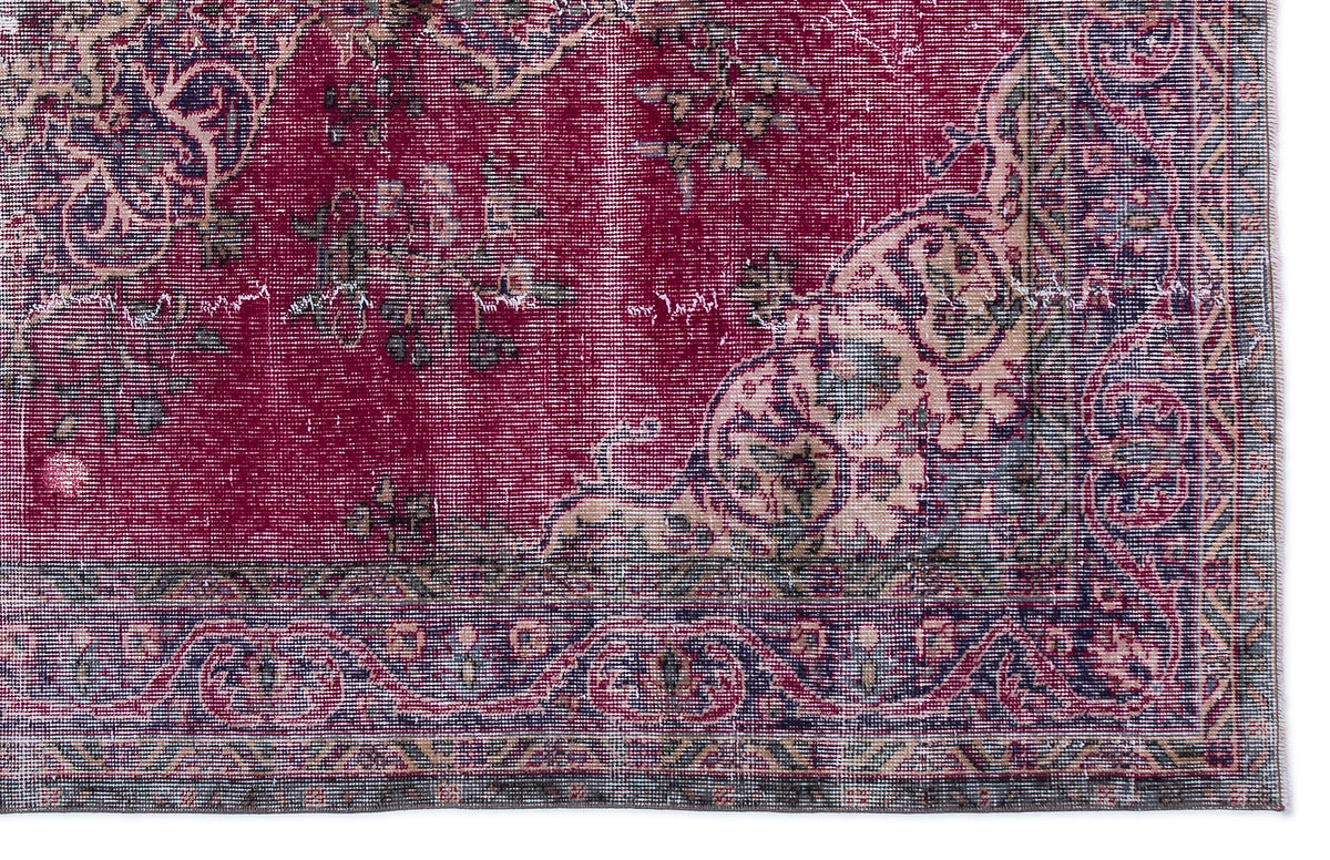 Deep red distressed rug with a traditional floral medallion pattern and a dark navy border.
