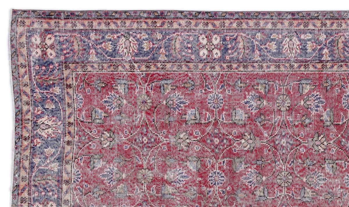 Red and blue traditional Persian-style rug with a floral vine pattern and a decorative border.