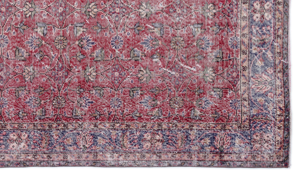 Red and blue traditional rug with a distressed floral medallion pattern and a detailed border.