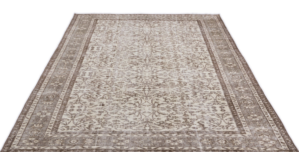 Taupe and cream vintage-style rug with a distressed floral medallion pattern and a wide decorative border.