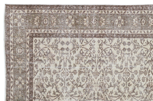 Load image 1 in gallery view. Brown and cream vintage-style rug with a distressed floral medallion pattern and a geometric border.