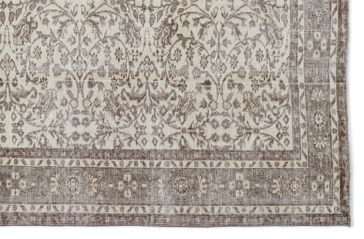 Taupe and cream rug with a distressed traditional floral medallion pattern and a wide decorative border.