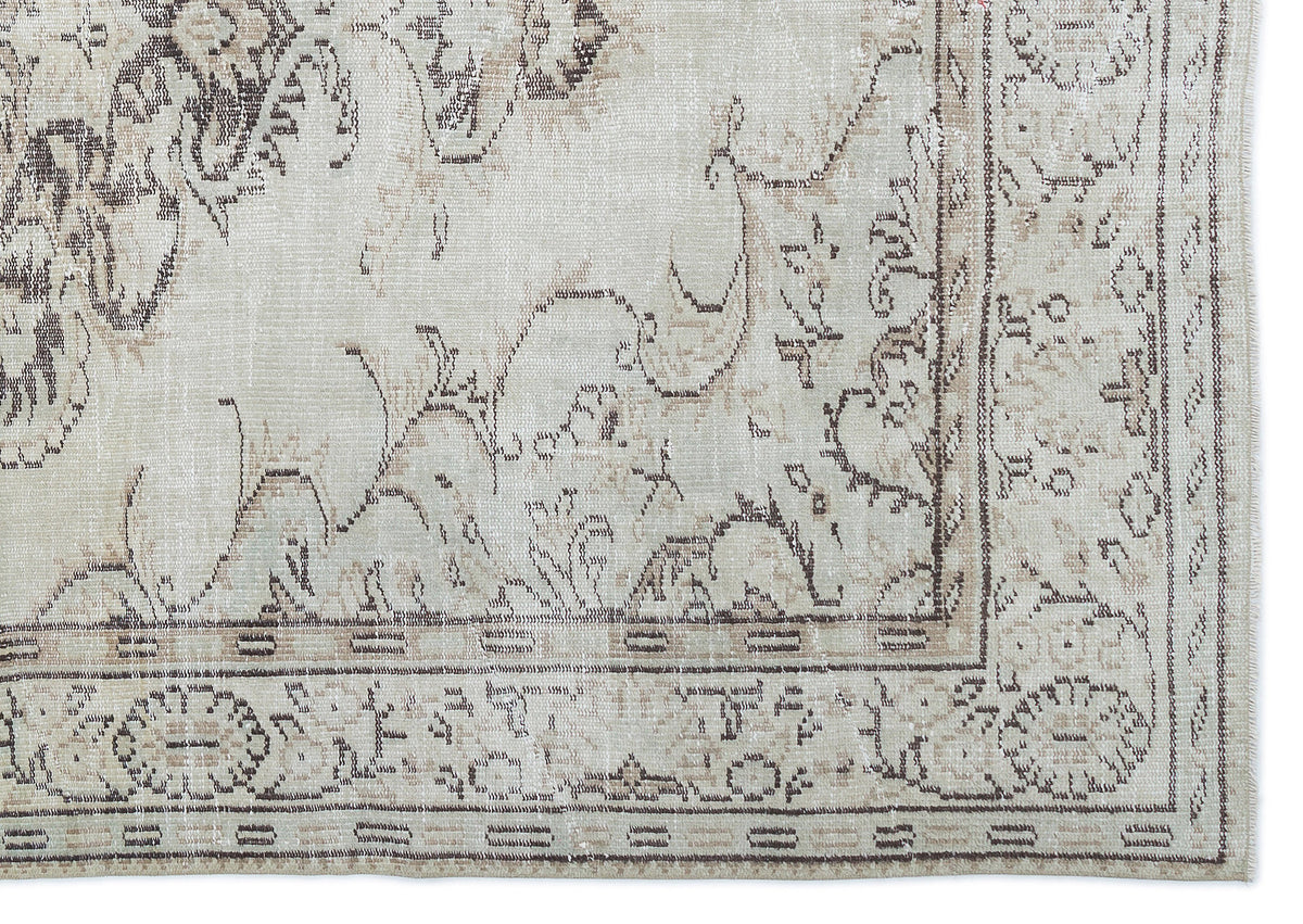 Beige and cream rug with a distressed, faded traditional floral medallion pattern and a detailed geometric border.