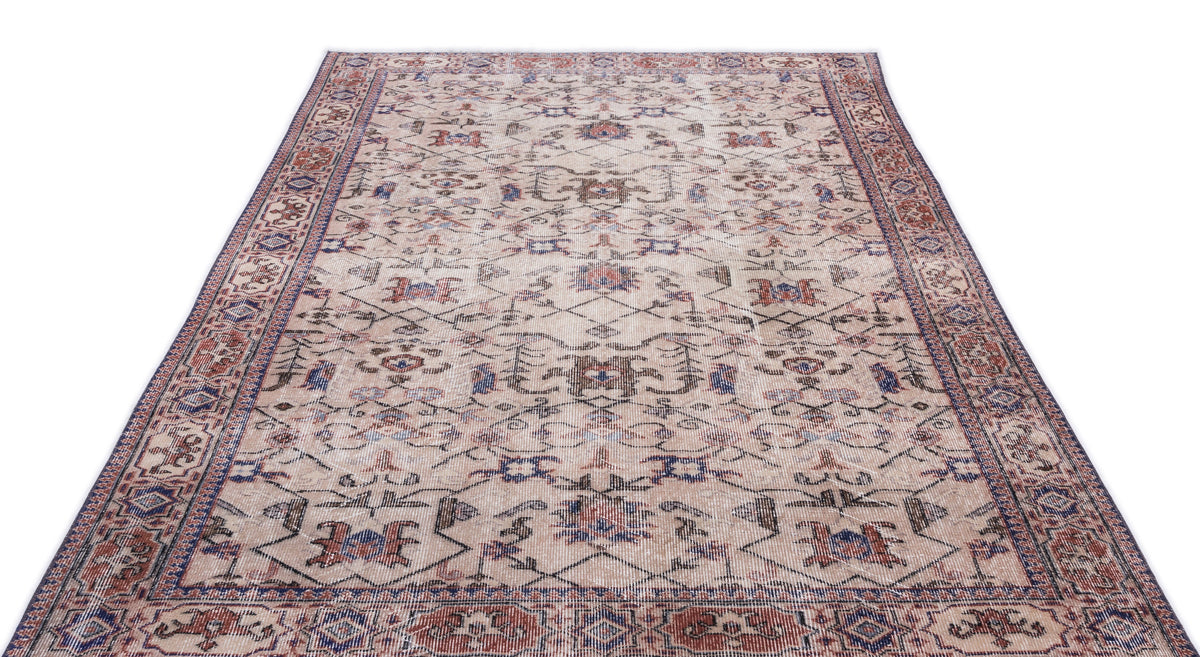 Beige traditional rug with a distressed floral medallion pattern in red, blue, and brown on a white background.