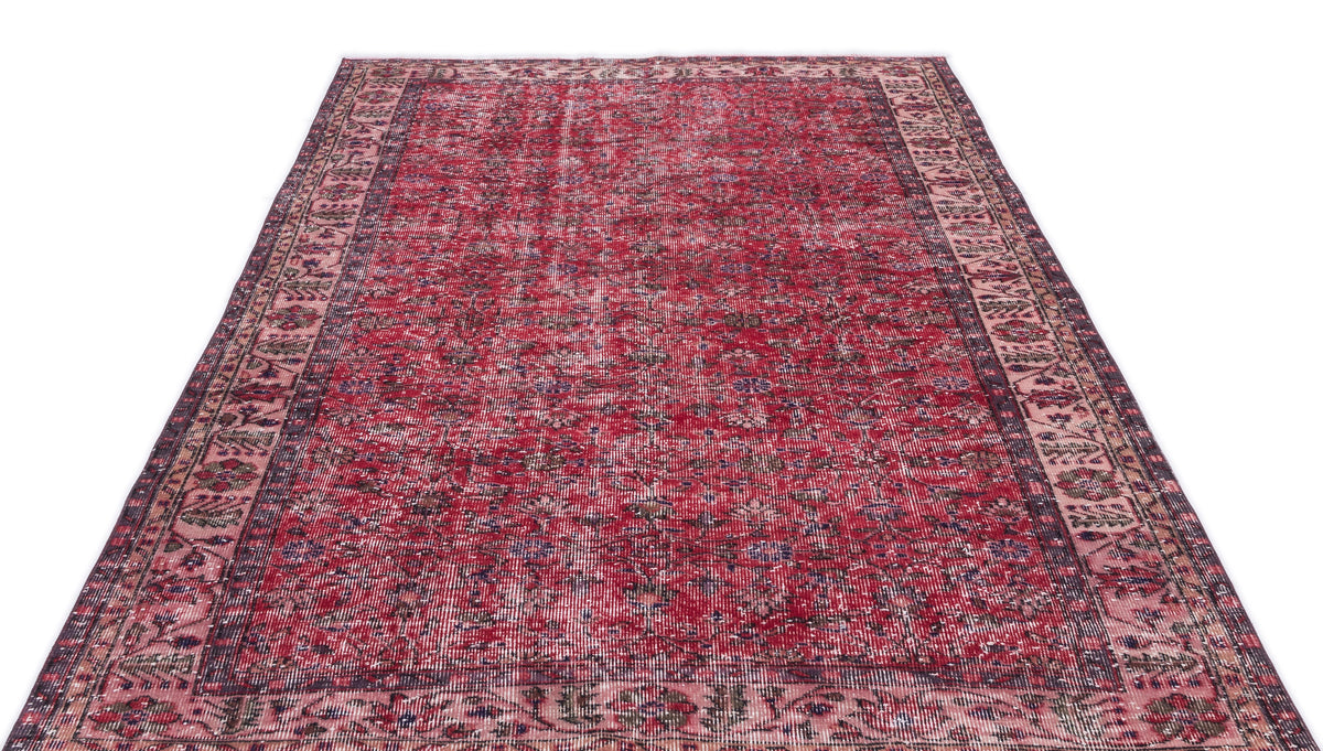 Distressed red Persian-style rug with a dark floral medallion pattern and a wide decorative border.