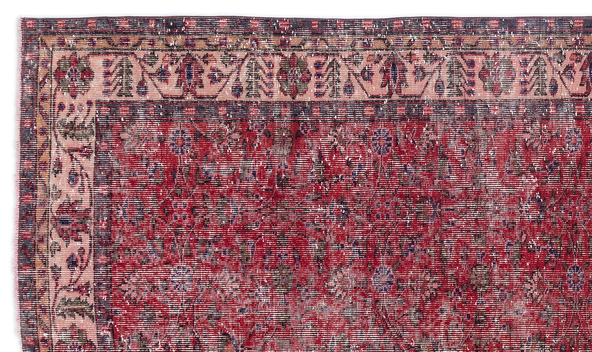 Distressed red and pink traditional rug with a floral medallion pattern and a dark charcoal border.