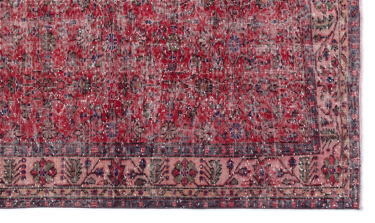 Distressed red and pink traditional rug with a faded floral medallion pattern and a dark border.
