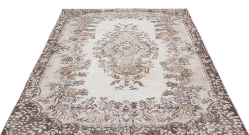 Load image 1 in gallery view. Cream and brown traditional rug with a central floral medallion and distressed border pattern on a white background.