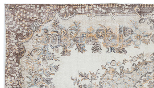 Load image 1 in gallery view. Distressed cream rug with brown and muted blue floral medallion patterns and a decorative border.
