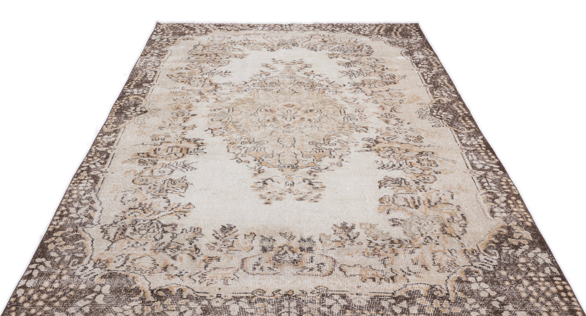 Cream and brown distressed rug with a traditional central medallion and ornate border on a white background.