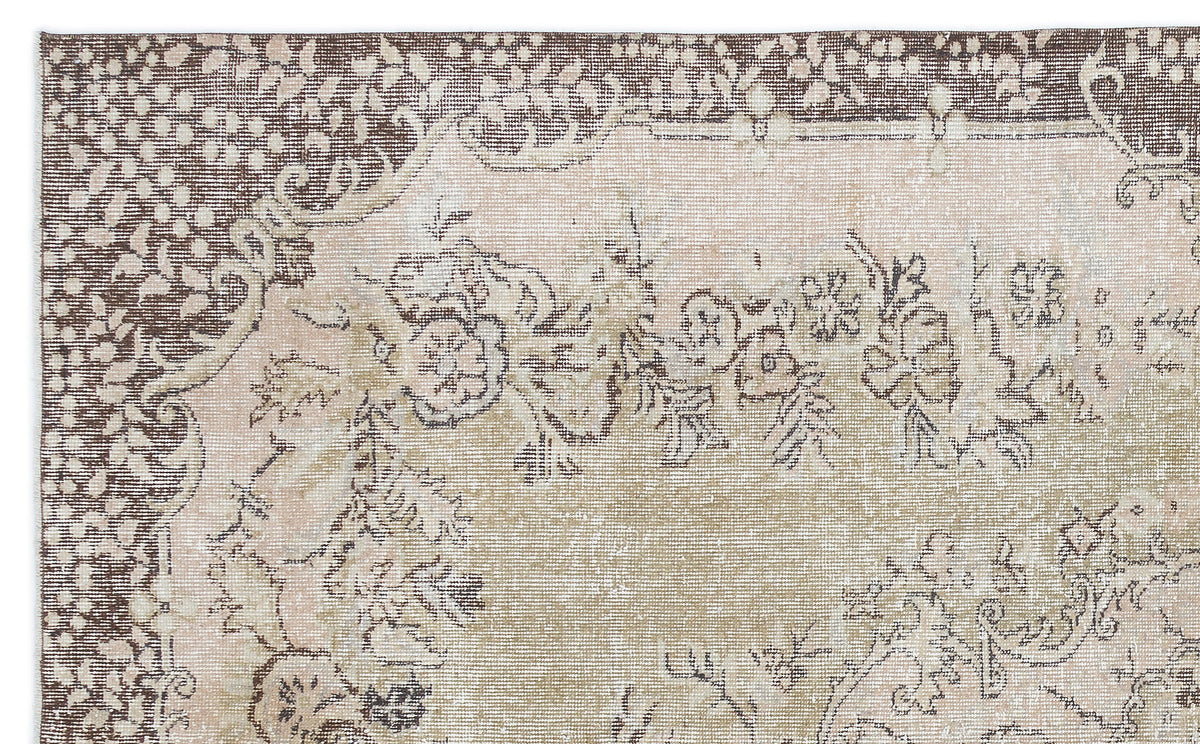 Brown and beige vintage-style rug with a distressed floral medallion pattern and a detailed border.