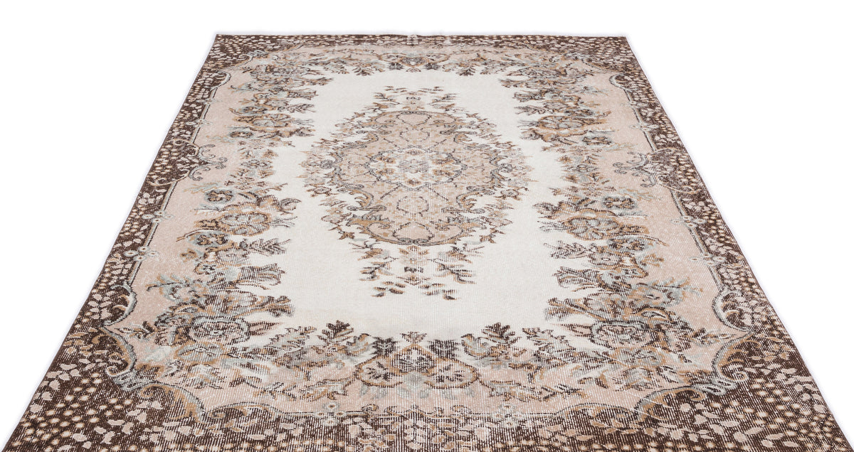 Cream and brown traditional rug with a central floral medallion and ornate border on a white background.