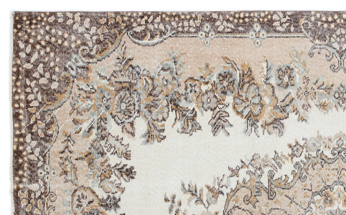 Distressed beige, brown, and light blue rug with a traditional floral medallion pattern and ornate border.